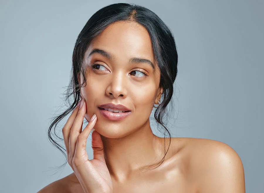 Woman feeling her right cheek - Cheek Fillers in Toronto, ON